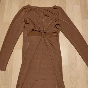 Festklänning - En supersnygg festklänning. Den är i ett skönt, svalkande material som rör sig väldigt fint. Klänningen har en väldigt fin kopparfärg.💕Den har inga tecken på användning. Säljer för att jag har fått för många klänningar⭐️