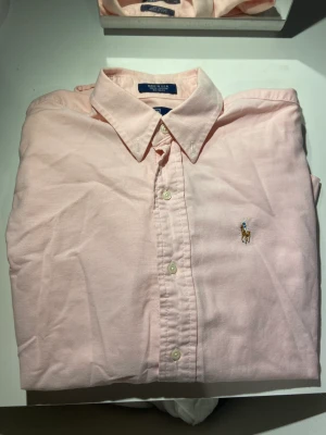 ralph lauren skjorta rosa - Säljer en super fin dam skjorta från ralph lauren i storleken 16 skulle säga xs eller s vuxen storlek skicket är som nytt skulle jag säga