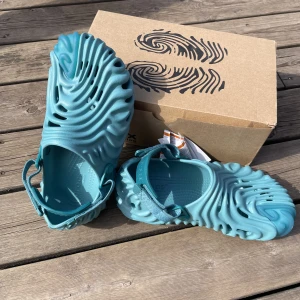 Crocs pollex tide  - Oanvända crocs limited edition originalpris 1500 kr. Jag har kvitto, de är väldigt sköna tofflor som man kan köpa till sommaren.