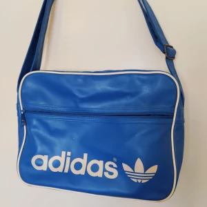 ADIDAS Blå Axelremsväska - ADIDAS Blå Axelremsväska i använt men riktigt bra skick. 