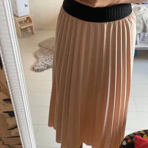 Maxi kjom - En lång maxi kjol som tyvärr är för kort på mig! Ljus rosa med svart kant med vikt material. Märket är ifrån pomp delux och är i storlek 146/152 men midjan sitter som en xs/s men midjan är stretchig!