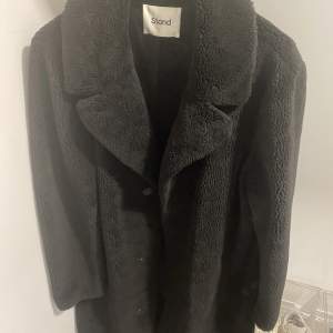 Lång faux fur kappa från Stand, storlek 48 svart. Nypris 3000, använd en säsong fåtal gånger. En söm på ungefär 2cm gått upp se bild 3.