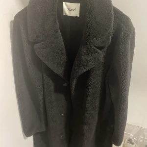 Stand kappa - Lång faux fur kappa från Stand, storlek 48 svart. Nypris 3000, använd en säsong fåtal gånger. En söm på ungefär 2cm gått upp se bild 3.