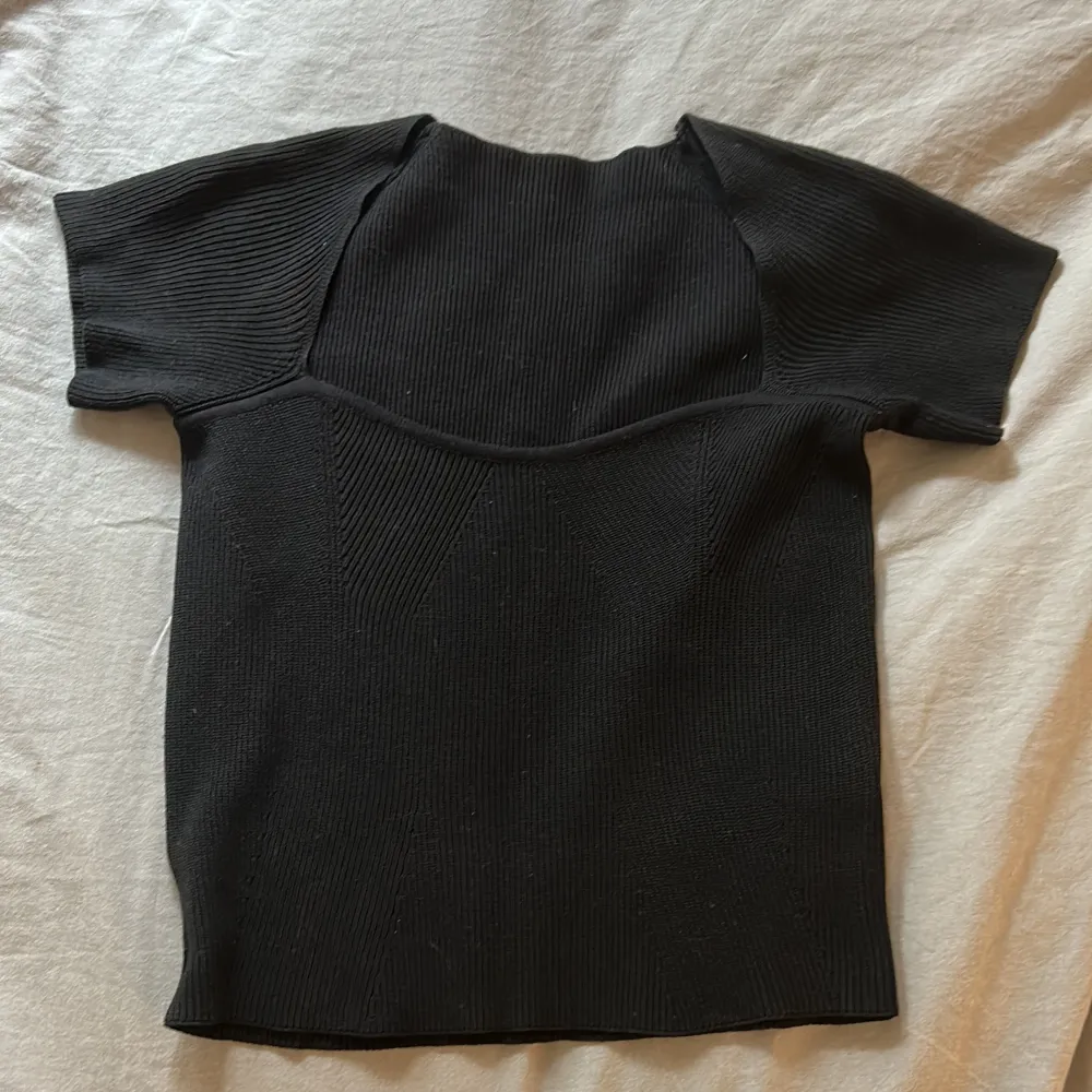 Ribbad svart T-shirt med strerchigt tyg (Köparen står för frakt!). Toppar.