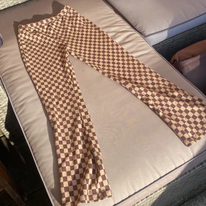 Utsvängda leggings - Utsvängda leggings med brun rutaktiga mönster jättefina säljer för att de inte kommer till användning