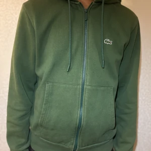 Lacoste kofta - Grön Lacoste kofta som jag köpte för 5 månader sen. Den har inte kommit till så mycket användning så därav vill jag sälja den.