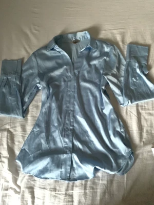 Ljusblå satinskjorta - Superfin skjorta från h&m i satin, storlek Xs men passar mig som har S-M  Bara andvänd en gång så den är i nyskick! Säljs då den inte andvänds