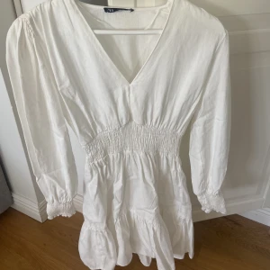 Långärmad vit klänning - Långärmad miniklänning i linnematerial från Zara. I strl XS. Aldrig använd. 150kr + frakt