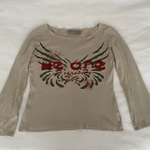 Tröja med coolt tryck - En väldigt cool och skön långärmad tröja från KappAhl. Den är i storlek 42/44/L men sitter ändå snyggt på mig som är S. Den har ett häftigt tryck med lite glittriga detaljer och materialet är väldigt behagligt att ha på sig!