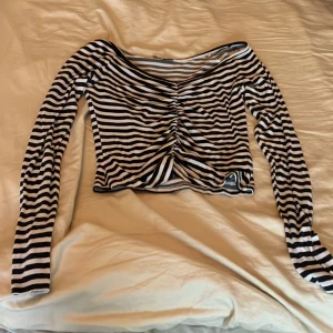 Svart och vit randig långärmad tröja - Tröjan är ”skrynkligt” designad som går ner längst mitten av tröjan. 