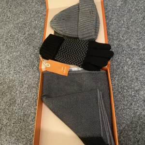 Hugo boss  - Säljer denna paket för den inte kommer till användning legat i garderoben sen jag fick den i present, man får med en halsduk, vantar och en mössa, helt nya aldrig använda! 