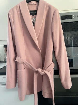 kappa  - Kappa från Stockholm LM har endast legat i garderoben Helfodrad. fickor fram och knytband i midjan. storlek 38 nypris 1599 Material: 60% ull. 30% viskos. 10% polyester.  Foder: 55% polyester. 45% viskos Tvättråd: kemtvätt Längd bak: 77 cm 