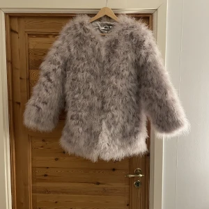DM grå pälsjacka - Grå pälsjacka (struts) från DM Maglic i längre modell. I fint skick då den endast är använd 2 gånger. Storlek S.