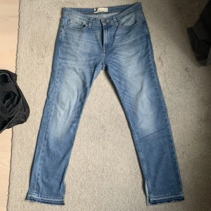 Jeans med slit - Blåa jeans med slit längst ner. Oklart vilken storlek det är men skulle säga L.