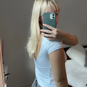 Weekday Open Back t-shirt  - Säljer denna tröja med öppen rygg från weekday. Endast använd vid två tillfällen, säljer pga kommer inte till användning. I en fin ljusblå färg. 