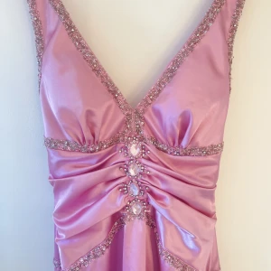 Rosa balklänning/festklänning helt ny  - Ny, oanvänd och inget fel på!(etikett på)  Storlek 36.  Märke: Forever Yours Stil: balklänning Rosa färg, broderad, lång, en skärning i mitten.  Priset är som på hemsidan!  Vid snabb kontakt kan priset diskuteras 