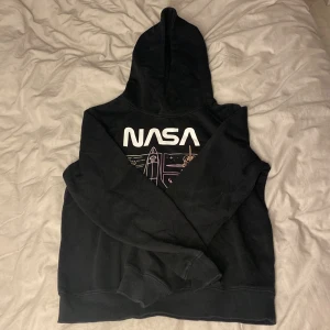 Luvtröja med Nasa tryck  - Svart luvtröja med nasa tryck. 