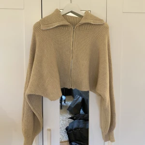 Stickad kofta  - En kort stickad kofta med krage 