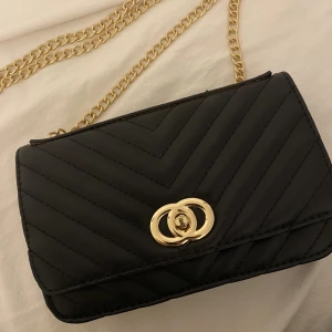 Väska - Säljer denna väskan med guld kedja då jag inte använder den ❤️ Använd endast en gång så är i väldigt bra skick 💕 Många fack i den (kanske lite svårt att se i bilden men kontakta bara för mer info/bilder 💖☺️)