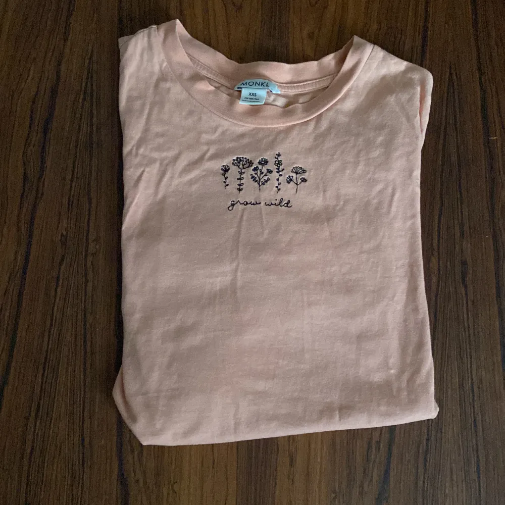 Säljer denna peach färgade tshirt. Det står grow wild på den och har några blommor på framsidan. Storlek: xxs. T-shirts.