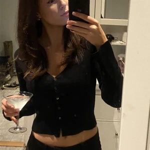 Svart topp - Superfin runt stickad svart topp med knappar som går att öppna. Jättebra skick 