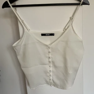 Vitt linne med knappar - Aldrig använd. Justerbara band.