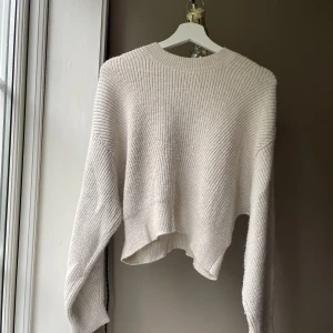 Croppad stickad tröja  - Croppad stickad tröja i en beige färg, från chiquelle. Endast använd fåtal gånger, super härligt material, bra kvalite. Köpt för 499kr