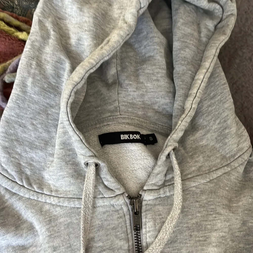 En grå tjocktröja med dragkedja från BikBok i strl S. Inte använd så mycket och inga skador. . Hoodies.