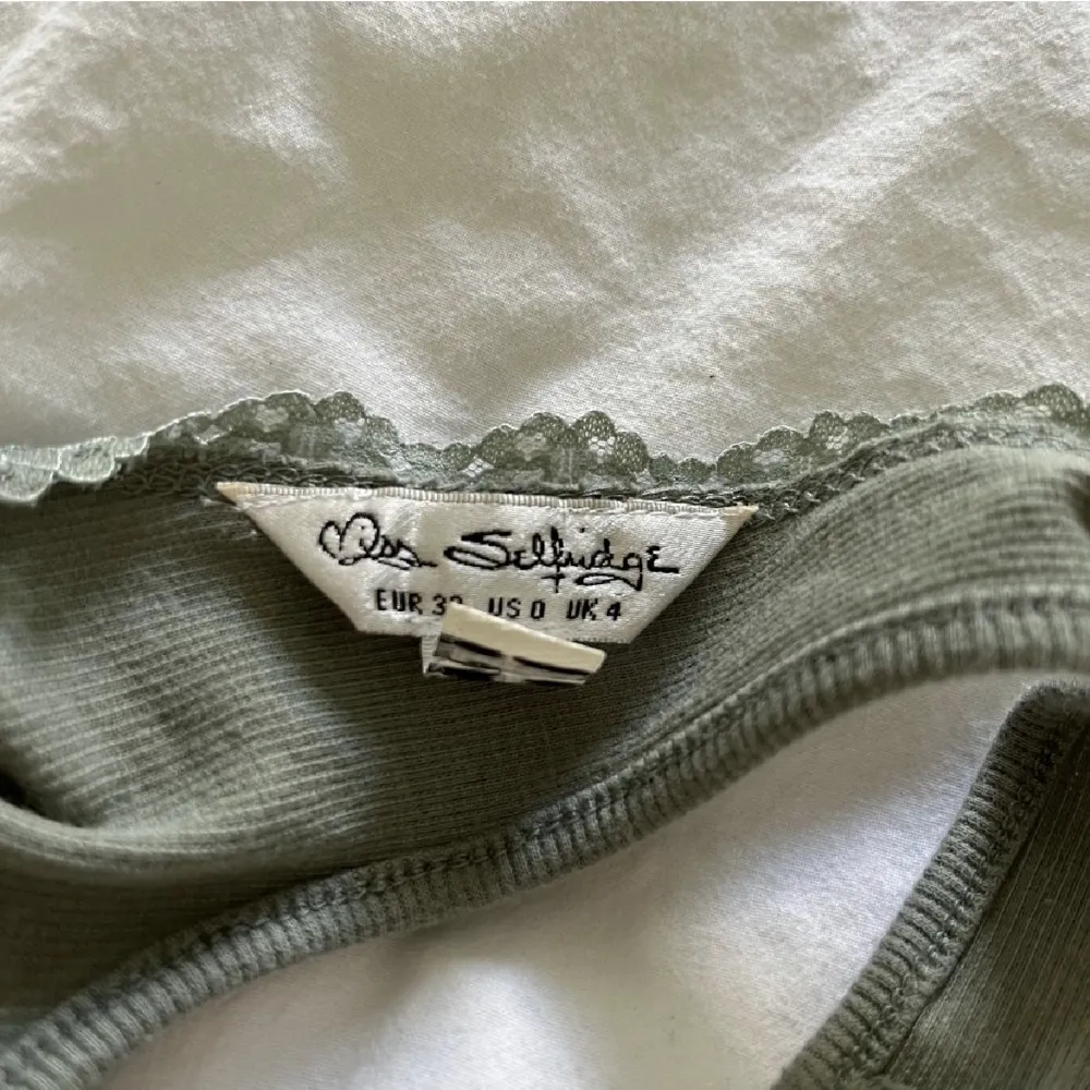 Grönt linne som sitter tight, stretchigt material, köpt för längesen men märket står på sista bilden. Toppar.