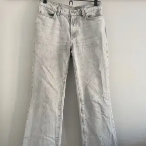 Ett par ljusgrå lågmidjade jeans