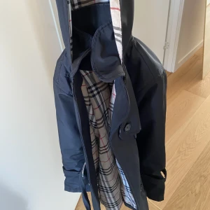Burberry trenchcoat - Hej säljer min burberry trenchcoat, strolek 12 år men passar mig som har xxs/xs. Man kan välja om bandet ska vara mönstrat eller svart. 