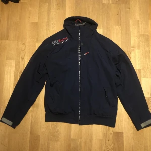 Race Marine Jacka!! - En riktigt fet race marine jacka som är mörkblå! Riktigt sjysst med flera detaljer som jag inte kunde få med på bilden så skriv gärna om ni har frågor! Jackan är i nyskick då den knappt har används! (1200 ish)