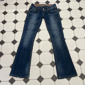Lågmidjade jeans - Lågmidjade utsvängda jeans. Glittrar lite. Midjemått tvärs över 38cm innerbenslängd 85cm