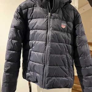 Gant vinterjacka  - Mörkblå Gant jacka som inte är använd många gånger. Den är som ny. Storlek 170, mörkblå. Ordinarie pris 2200kr. Jackan finns i Täby, hämtas på plats. 