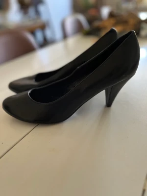 Svarta pumps - Svarta skor med klackar, använda två gånger, märken bak, se bild