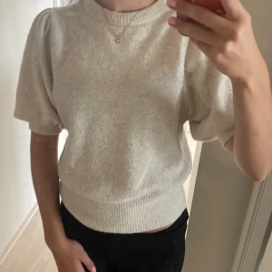 Kortärmad stickad tröja - Beige stickad tröja med korta armar. I bra skick 