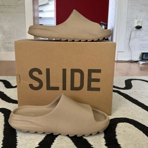 Yezzy slide - Säljer min yezzy slides för dom inte används alls dom är i 43 men skulle säga dom passar om man har 41 också köpta på StockX skick 7/10 nertrampade vid sulan men annars fina skriv om ni vill ha mer bilder 