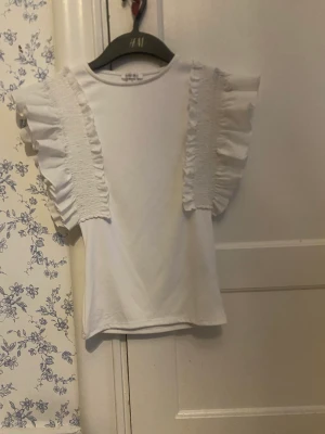Vit T-shirt med volang - Aldrig använts för jag köpte den i för liten storlek 💞 