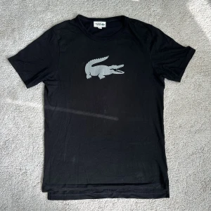 Lacoste t-shirt - Säljer en t-shirt från Lacoste då den inte längre kommer till användning. Tröjan är i princip nyskick och har knappt blivit använd.  Storlek S, pris exklusive frakt. 