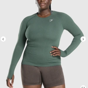 Gymshark tröja grön - Gymshark vital seamless 2.0 long sleeve top. I färgen Dark green marl. Endast använd en gång pga köpte fel storlek 💗