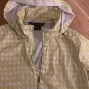 Armani exchange neon green training jacket with hidden packable hood inside the zip collar , size XS, in very good condition 