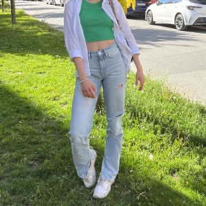 Blåa jeans - Ljusblå, raka, högmidjade jeans från Gina Tricot med slits och lite hål. Fint skick!