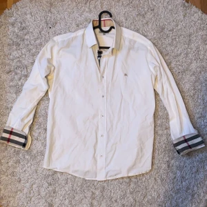 Burberry skjorta Vit storlek M - Säljer denna riktigt fräscha och Stilliga burberry skjortan som som är i riktigt bra skick. Skjortan är i storlek L men passar M (modellen är 179cm och 65kg) Säljer denna för ett schysst pris som är 899kr.  Tveka inte på att höra av er vid funderingar!🙌🍾