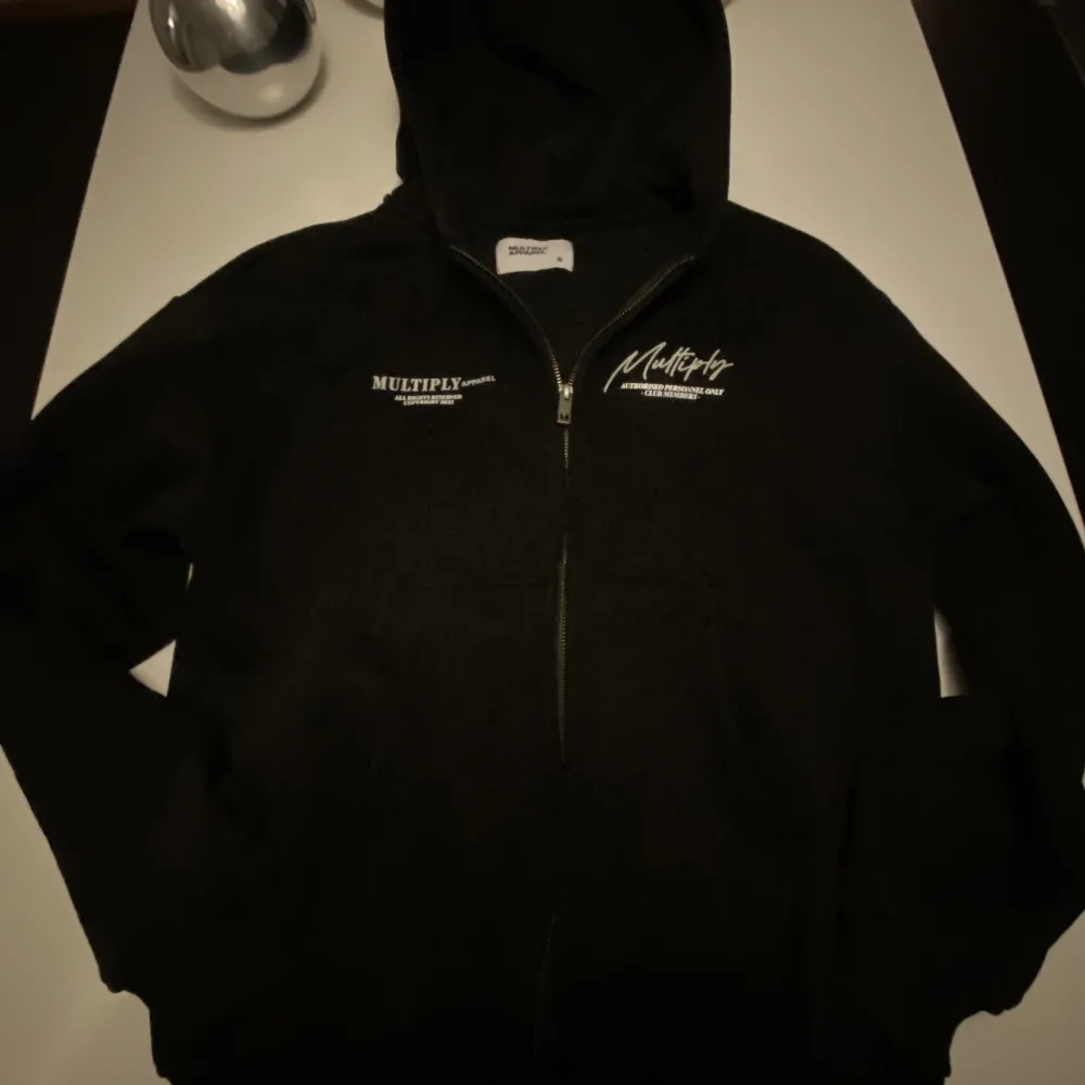 Nästan helt oanvänd svart Multiply Apparel zip hoodie använd (2-3 gånger) säljs pga fel storlek Ny pris ca 1000kr.  Kan förhandla om priset. Skriv Dm om intresserad.. Hoodies.