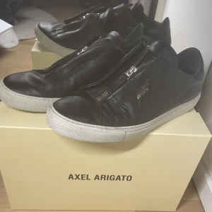 Feta Axel Arigato Zip Skor!  - Tja säljer nu mina sparsamt använda Arigato zip skor🙌 Skick 7/10. Storlek 44 kan även passa 43. Priset är inte hugget i sten🙏 Frågor? Skriv till mig👍