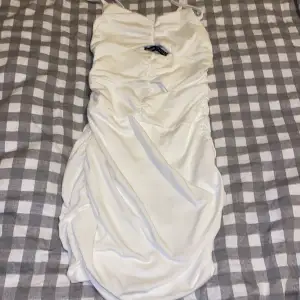 Fin vit klänning med skrynkliga detaljer så den formar sig efter kroppen samt lite öppning framifrån som syns på bilderna klänningen är köpt på SHEIN för ungefär 1 år sedan och är aldrig använd så därav säljs nu är i storlek 34 XS 