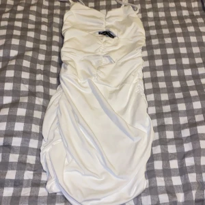 Vit kort klänning  - Fin vit klänning med skrynkliga detaljer så den formar sig efter kroppen samt lite öppning framifrån som syns på bilderna klänningen är köpt på SHEIN för ungefär 1 år sedan och är aldrig använd så därav säljs nu är i storlek 34 XS 