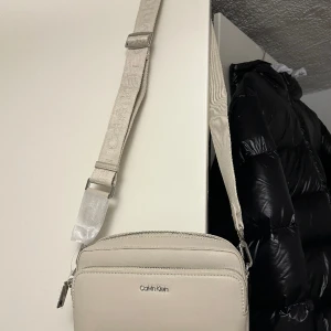 Calvin Klein Must Camera Bag Unisex - Axelremsväska  - Helt Ny: Calvin Klein Must Camera Bag Unisex - Axelremsväska, Helt slutsåld online 