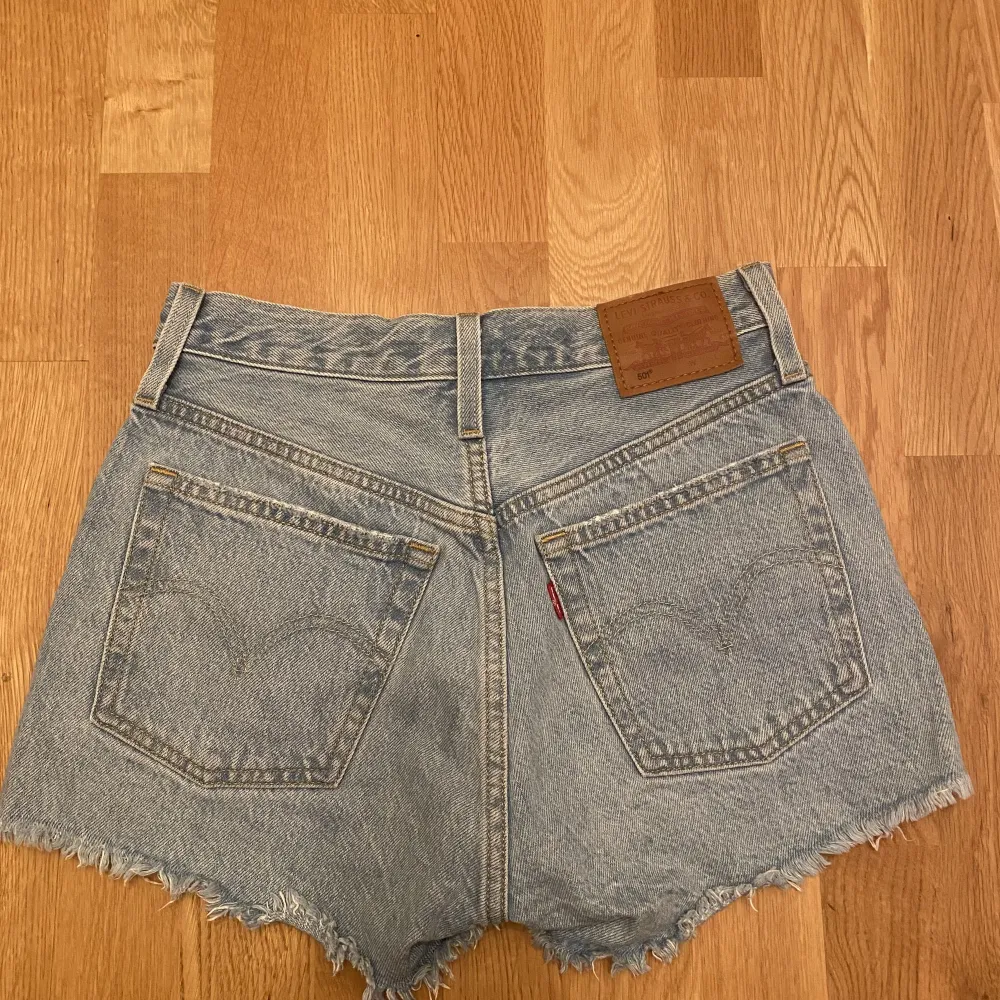 Levis 501 jeansshorts, ljusblåa. Ganska så använda, så smått uttöjda men sitter fortfarande väldigt bra. Super bra kvalité! Säljs då de har blivit för små för mig. Ordinarie pris: 669kr. Shorts.