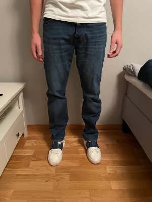 Wrangler jeans - Mörkblåa jeans från Wrangler | Storlek: 31/30 - Skicket är väldigt bra, endast använda ett få tal gånger - Vårat pris: 349 - Nypris: 699 - Modellen är 180